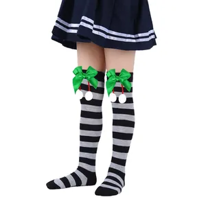 Detailed view of children's Christmas striped over-the-knee socks with green bows