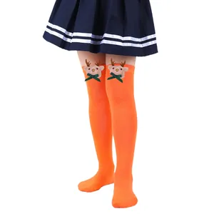 Close-up of bright orange kids' Christmas over-the-knee socks with reindeer doll detail