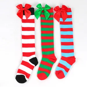 Detail view of colorful striped Christmas knee-high socks with satin bows for girls.
