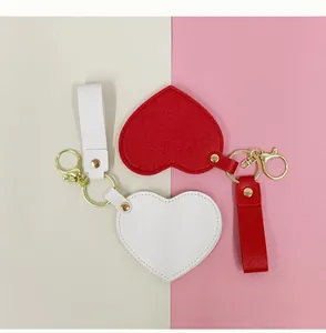 Gros plan sur les miroirs compacts en forme de cœur rouge et blanc avec porte-clés