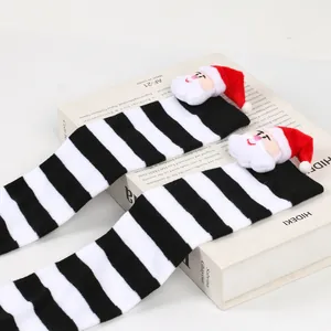 Detailed view of striped Christmas long socks with plush Santa Claus doll decoration
