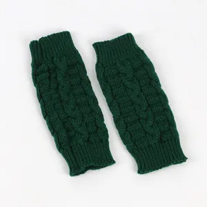 Close-up detail of dark green knitted fingerless gloves showing the thick cable knit texture