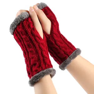 Gros plan sur des mitaines rouges en tricot torsadé avec une bordure en fausse fourrure
