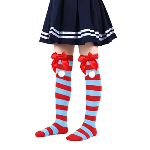 Detailed view of children's striped Christmas socks with red bows and white pom-poms.