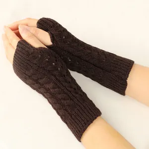 Detail of brown cable knit fingerless gloves with hollow-out pattern design