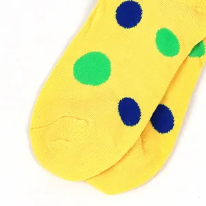 Close-up of bright yellow over-the-knee socks with green and blue polka dots