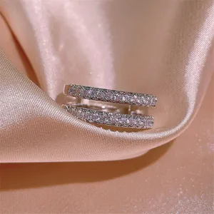 Nahaufnahme eines eleganten zweireihigen Moissanit-Rings mit modernem Design auf rosa Satin.