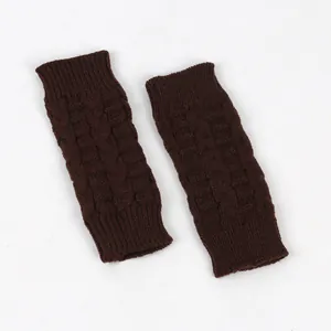 Detail of dark brown cable knit fingerless gloves showing warm winter texture.