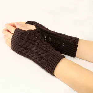Close-up detail of brown cable-knit fingerless gloves featuring a hollow-out knit pattern.