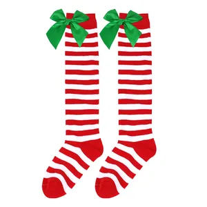 Festive red and white striped Christmas knee-high socks with large green satin bows for girls.