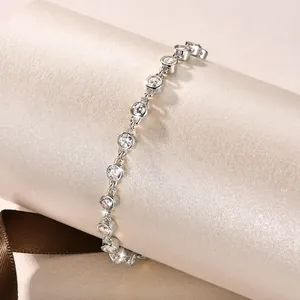 Macro view of a silver bracelet with brilliant bezel-set clear round cubic zirconia
