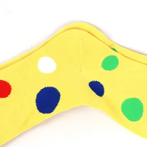 Close-up of yellow knit fabric with vibrant multi-colored polka dot pattern details.