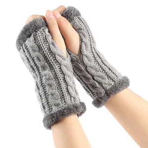 Gros plan détaillé de mitaines en tricot torsadé gris avec bordure en fausse fourrure