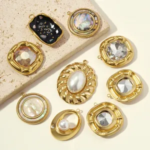 Detailed view of various vintage gold stainless steel pendants with shell and pearl