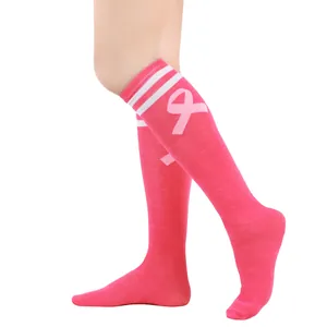 Close-up of pink knee-high socks with white stripes and breast cancer awareness ribbon