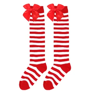 Detail of festive red and white striped knee-high socks featuring large satin bows.