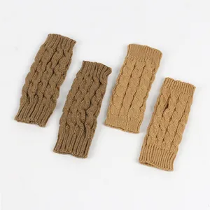 Close-up of twist-knit cable pattern on warm fingerless gloves in brown and beige.