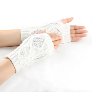 Vue détaillée de gants en tricot torsadé blanc avec un motif élégant de losanges