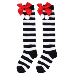 Girls Christmas knee-high socks with black white stripes red bows and pom-poms