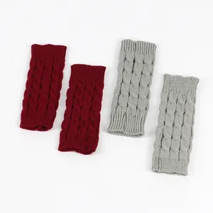 Detailed view of cable knit fingerless gloves in dark red and light grey acrylic yarn
