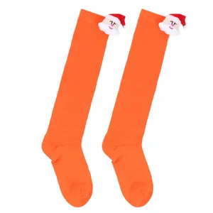 Festive children's orange knee-high Christmas socks featuring cute 3D Santa Claus doll accents