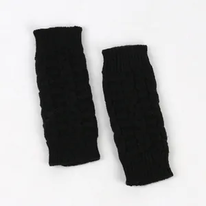 Close-up detail of black cable knit fingerless gloves showing high-quality soft wool texture