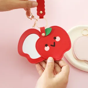 Cute red apple-shaped PU leather keychain with a built-in portable makeup mirror.