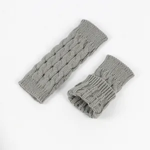 Detailed view of grey cable knit fingerless gloves with soft acrylic texture