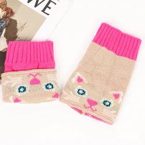 Détail du motif chat en tricot sur des chauffe-bottes rose et beige confortables