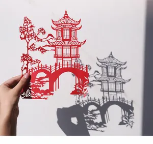 Détail d'un art du papier découpé rouge DIY montrant une pagode chinoise avec ombre.