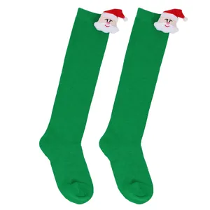 Detailed view of green knee-high children's socks featuring a 3D plush Santa Claus