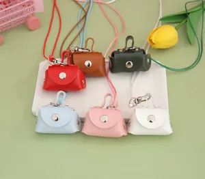 Detailed view of six colorful mini PU leather coin purses with lanyards on a white display plate