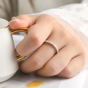 Gros plan d'une bague empilable en moissanite étincelante sur une main avec dentelle