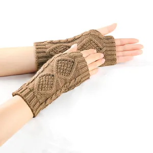 Gants sans doigts marron en tricot torsadé sur fond blanc, vue détaillée du tissu.