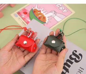 Detail of red and green mini PU leather coin purses with lanyards for earphone storage
