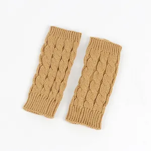 Close-up of tan knitted fingerless gloves with a classic cable-knit pattern and soft texture.