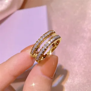Nahaufnahme eines zweireihigen Moissanit-Rings in Gold mit funkelndem Design