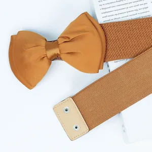 Detailed view of mustard ginger chiffon bow on wide elastic belt with snap closure