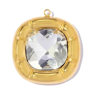 Macro view of a square gold-plated stainless steel pendant featuring a large clear crystal center