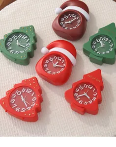 Detailed view of assorted Christmas tree and Santa hat shaped table clocks in festive colors