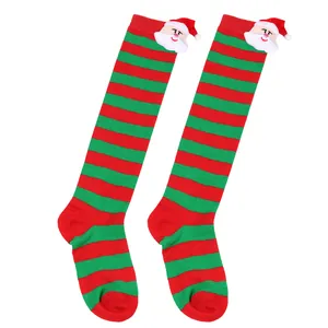 Detail of children Christmas socks with red and green stripes and Santa Claus doll