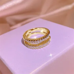 Detaillierte Makroansicht eines eleganten zweireihigen Moissanit-Goldrings auf lila Box