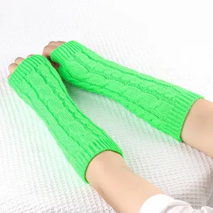 Dettaglio di scaldabraccia lunghi verde neon in maglia a trecce con trama definita.