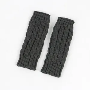 Detailed macro view of the dark grey cable knit pattern on fingerless winter gloves