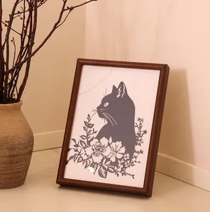 Vue détaillée de l'art de la sculpture sur papier de chat dans un cadre en bois classique.