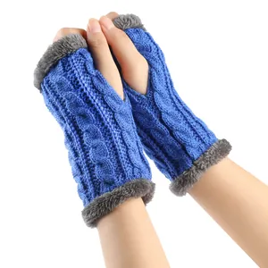 Détail de mitaines en tricot torsadé bleu avec bordure en fausse fourrure grise pour hiver