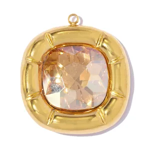 Macro detail of a square gold-plated stainless steel pendant with a large faceted gemstone.