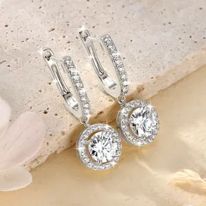 Elegante Moissanit-Ohrringe mit rundem Halo-Anhänger auf einer Steinplatte präsentiert