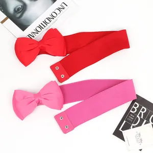 Detailed view of red and pink elastic waist belts with oversized chiffon bows for dresses.