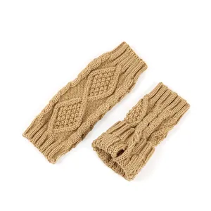 Gros plan montrant la texture en tricot torsadé et losanges des mitaines de couleur beige